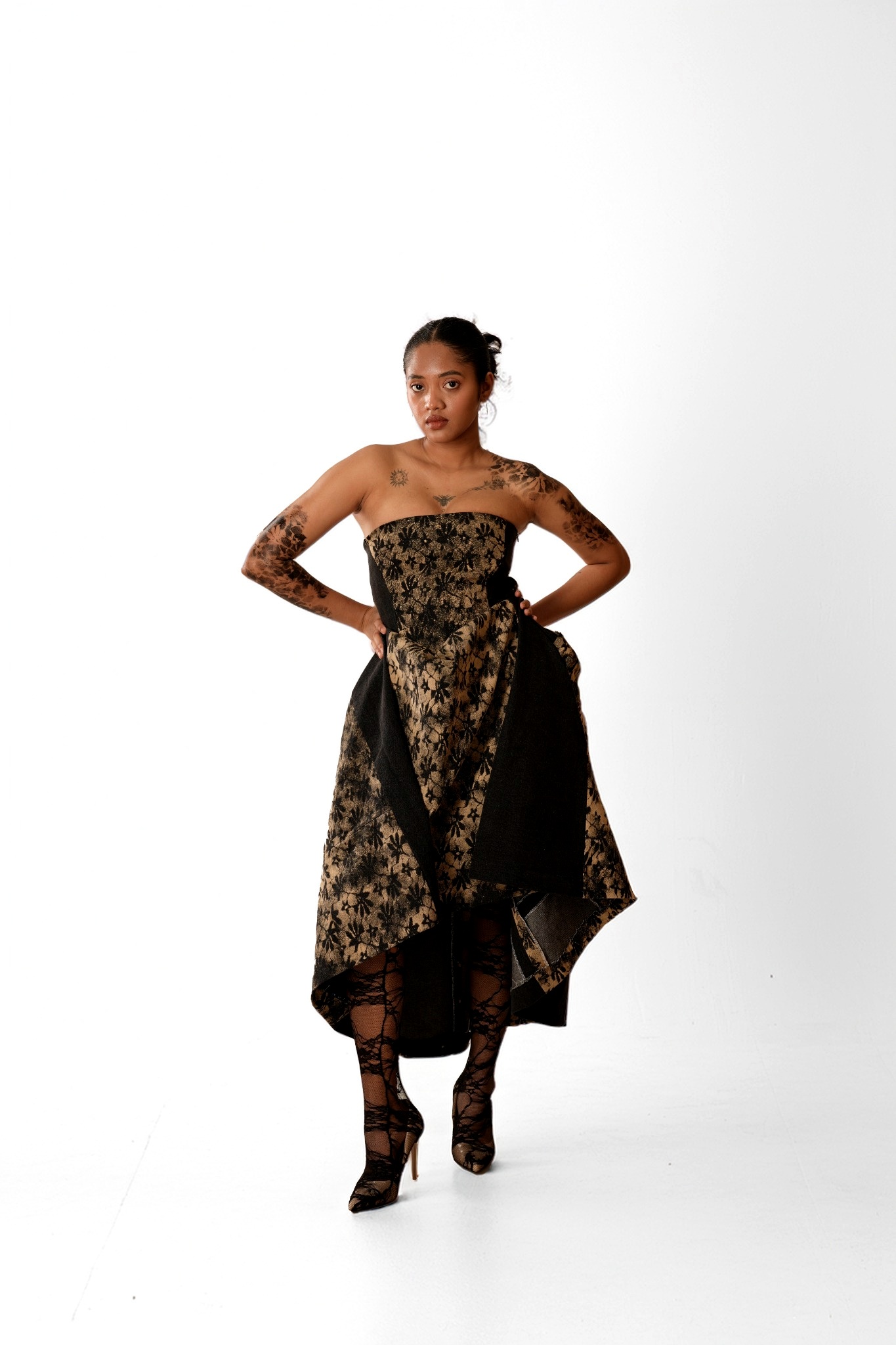 Model standing in a black and gold textile look